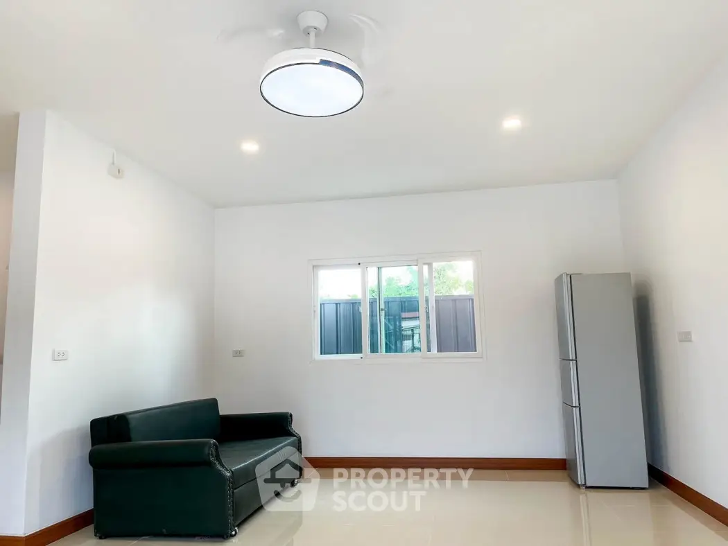 Minimalist living room with sleek sofa and modern fridge, perfect for contemporary lifestyle.