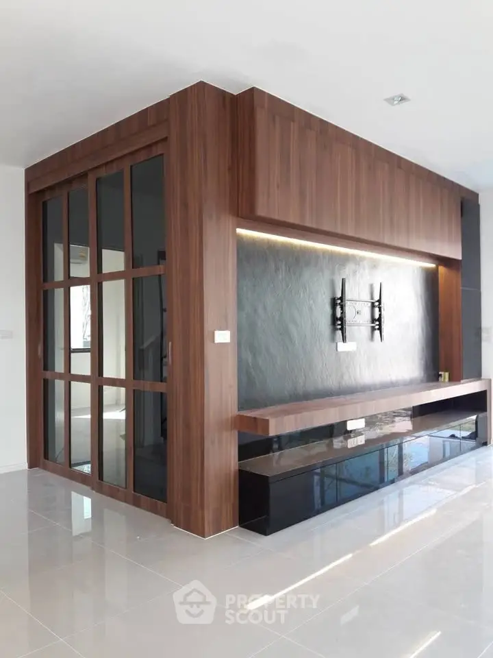 Modern living room with sleek wooden paneling and TV mount