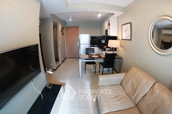 Modern living room with sleek TV and cozy dining area in open layout.