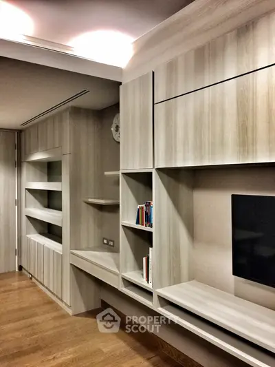 Modern living room with sleek wooden shelving and built-in TV unit