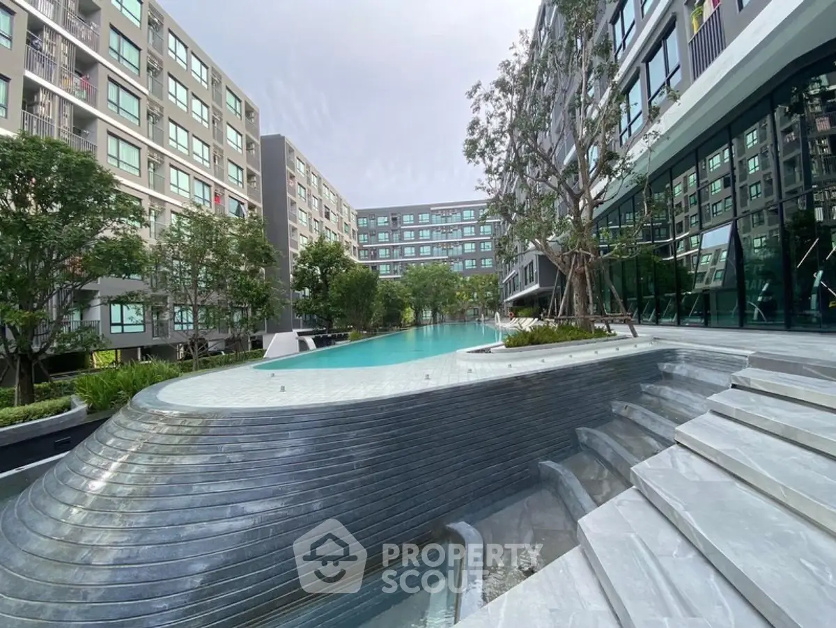 Modern apartment complex with stunning pool and lush greenery