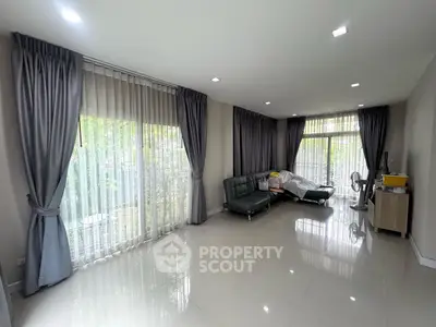 Spacious living room with modern decor and large windows for natural light