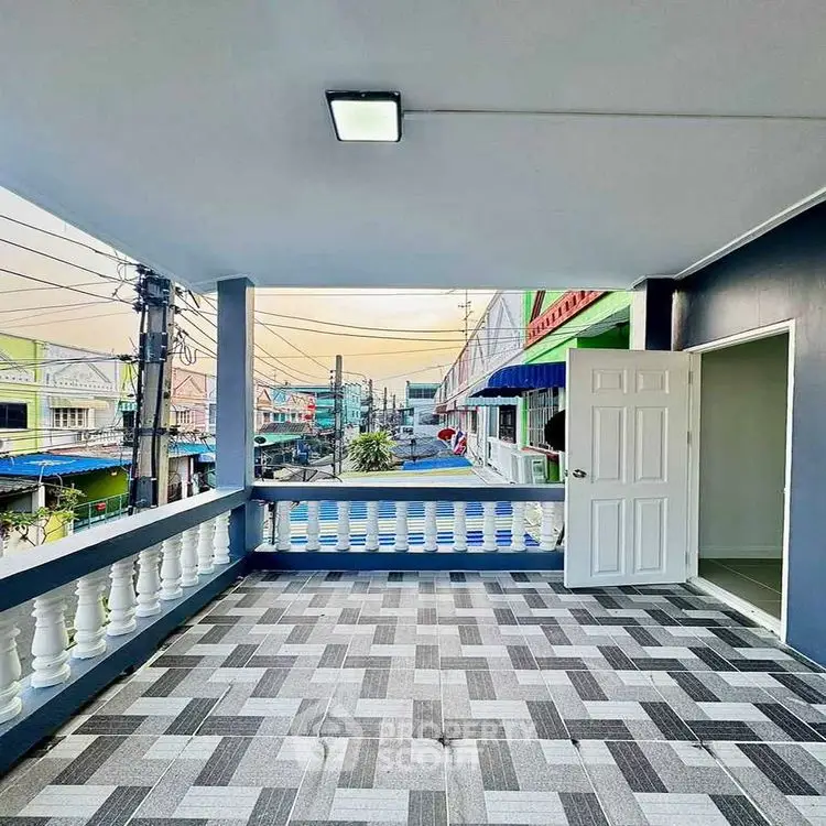 Spacious balcony with modern tile flooring and city view, perfect for relaxation.