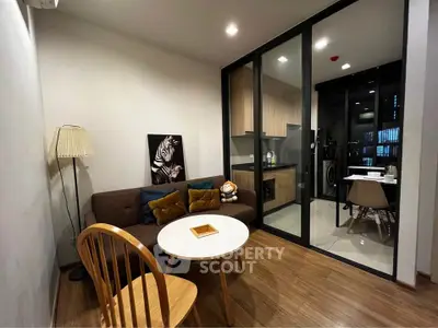 Modern living room with cozy seating and open kitchen layout in stylish apartment.