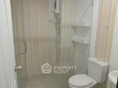 Modern bathroom with shower and toilet in a stylish tiled design.