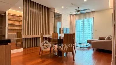 Modern living room with wooden flooring, stylish furniture, and large windows for natural light.