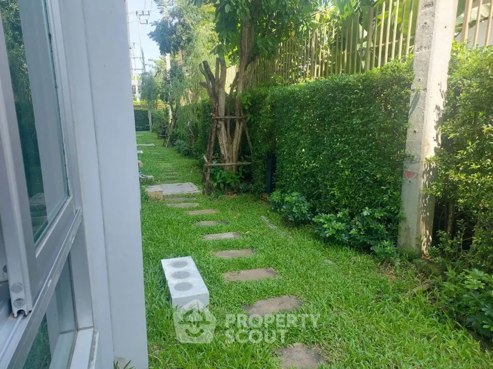 Charming garden pathway with lush greenery and stepping stones in a serene residential setting.