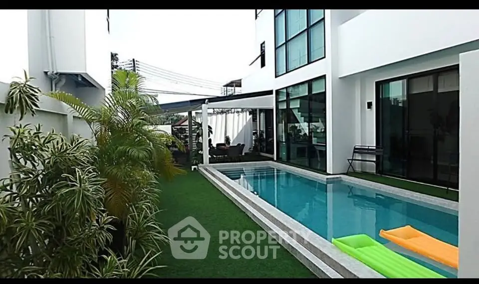 Luxurious modern home with private pool and lush greenery, perfect for relaxation and entertainment.