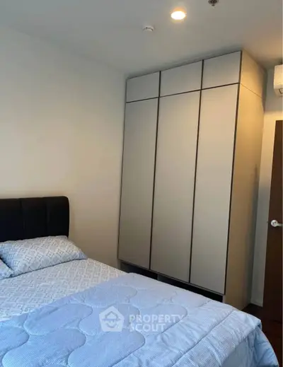 Cozy bedroom with modern wardrobe and comfortable bed in a stylish apartment.