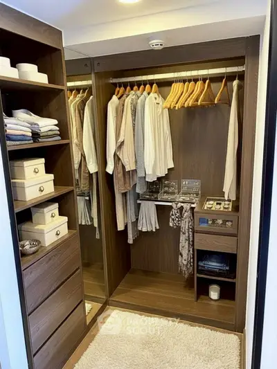 Luxurious walk-in closet with wooden shelves and ample hanging space, perfect for organized living.