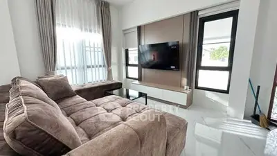 Luxurious living room with plush sectional sofa and modern TV setup.