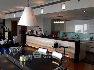Luxurious open-plan kitchen and dining area with modern lighting and sleek design.