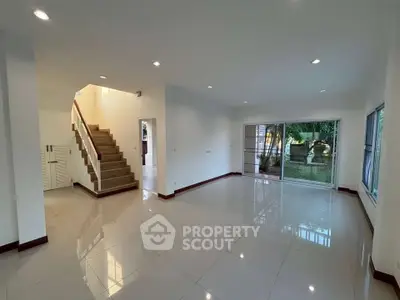 Spacious modern living room with garden view and elegant staircase