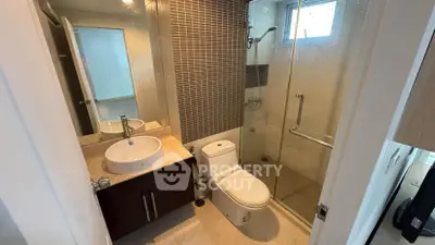Modern bathroom with glass shower and stylish vanity in contemporary apartment.