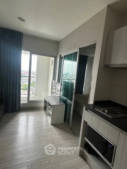 Modern apartment interior with open layout and city view from balcony.