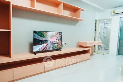 Modern living room with sleek TV unit and open shelving, showcasing minimalist design and bright ambiance.
