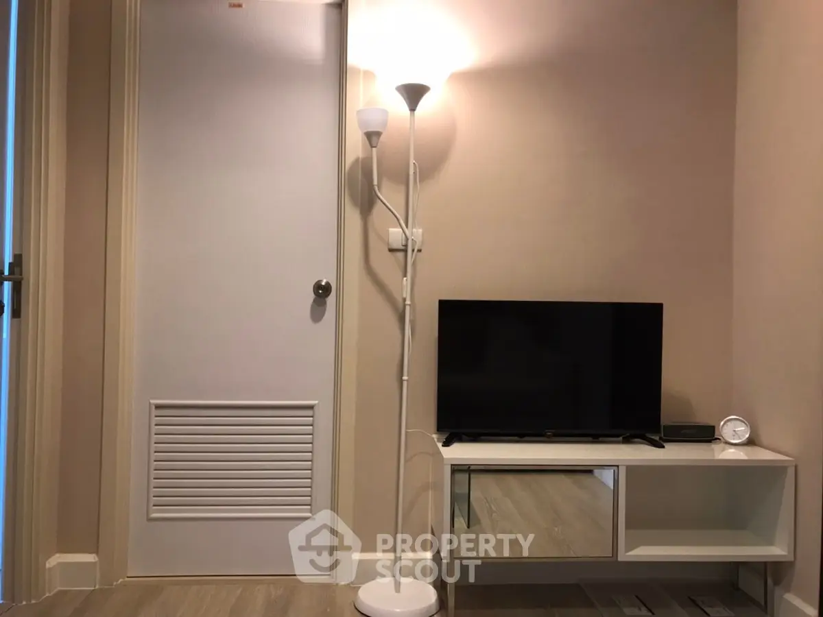 Cozy living room with modern TV stand and floor lamp, perfect for relaxation.