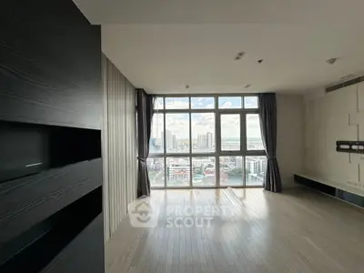 Spacious modern living room with large windows offering stunning city views, perfect for urban living.