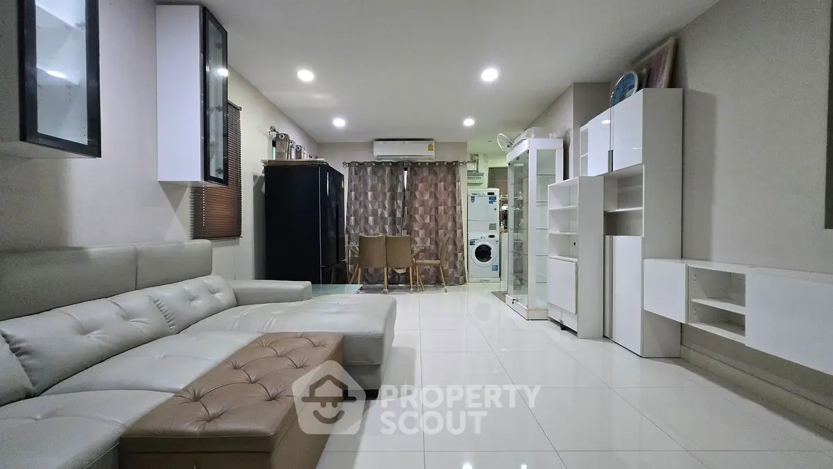 Modern living room with sleek furniture and washing machine in open layout