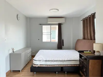 Spacious bedroom with modern furnishings and natural light, featuring a comfortable bed and stylish decor.