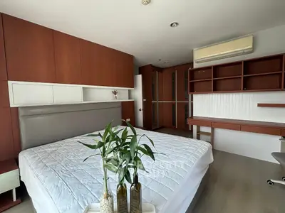 Spacious bedroom with modern wooden furnishings and elegant decor