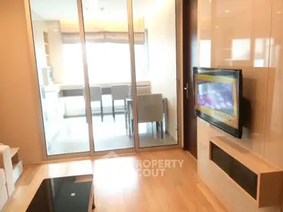 Modern living room with glass partition and wall-mounted TV in stylish apartment