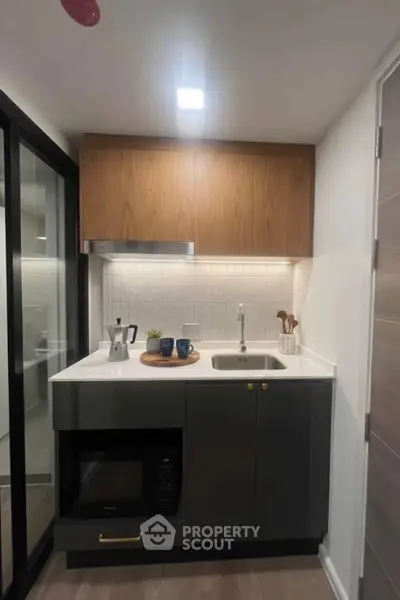 Modern compact kitchen with sleek cabinetry and built-in appliances