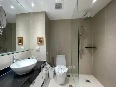 Modern bathroom with sleek design, featuring a glass shower and stylish sink.