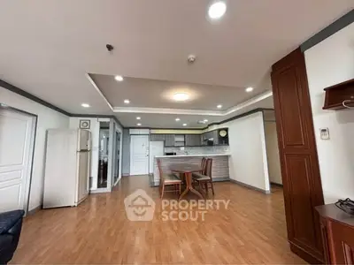 Spacious open-plan living room with modern kitchen and wooden flooring