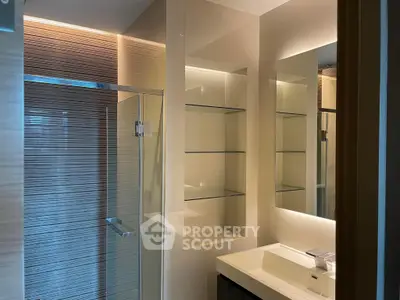 Modern bathroom with glass shower and sleek lighting