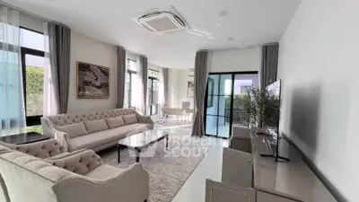 Luxurious modern living room with elegant furniture and large windows offering natural light.