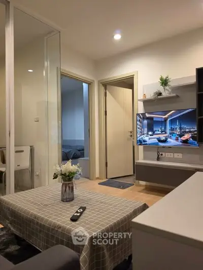 Modern living room with open layout and stylish decor, featuring a wall-mounted TV and cozy seating area.