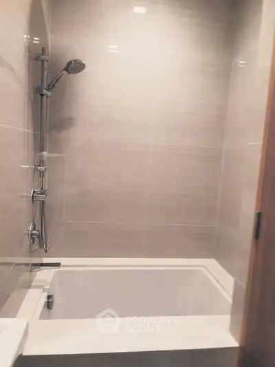 Modern bathroom with sleek bathtub and shower fixtures in a contemporary design.