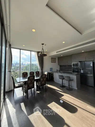 Luxurious open-plan kitchen and dining area with stunning city views and modern furnishings.