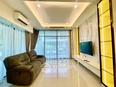 Luxurious living room with modern design, featuring a sleek sofa, wall-mounted TV, and ambient lighting.