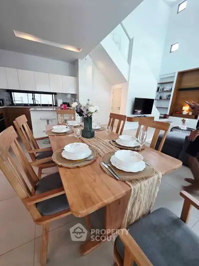 Modern open-plan dining and kitchen area with elegant wooden furniture and stylish decor.