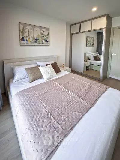 Spacious bedroom with modern decor and ample storage in a stylish apartment.