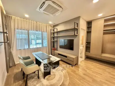 Modern living room with stylish furniture and built-in storage, featuring a sleek air conditioning unit.