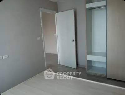 Spacious empty bedroom with built-in closet and modern flooring.