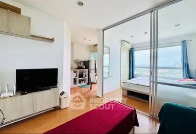 Modern apartment with open living room and bedroom, featuring large windows and city view.