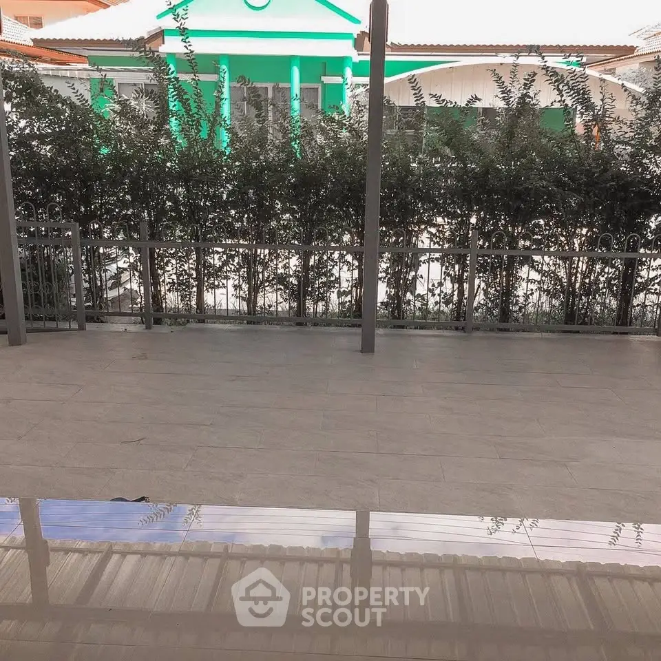 Spacious patio with modern fencing and lush greenery for serene outdoor living.