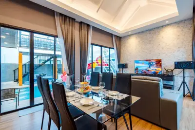 Luxurious living room with pool view, modern decor, and elegant dining area in a stylish home.