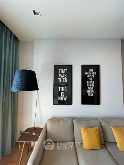 Modern living room with stylish decor and cozy sofa, featuring motivational wall art.