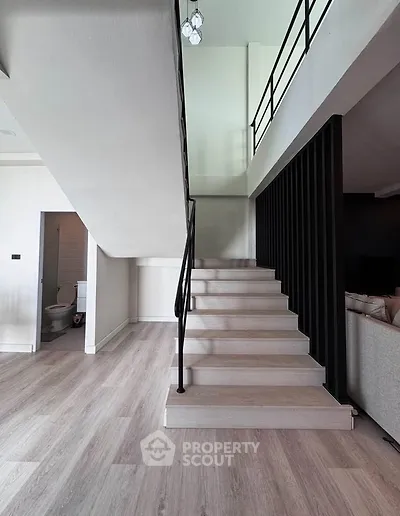 Modern duplex interior with sleek staircase and open living space