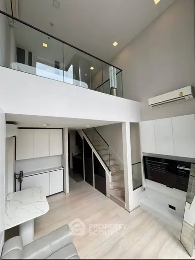 Modern loft apartment with high ceilings and mezzanine bedroom, featuring sleek design and open living space.