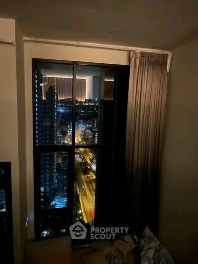 Stunning night city view from a high-rise apartment window, showcasing urban lights and skyline.
