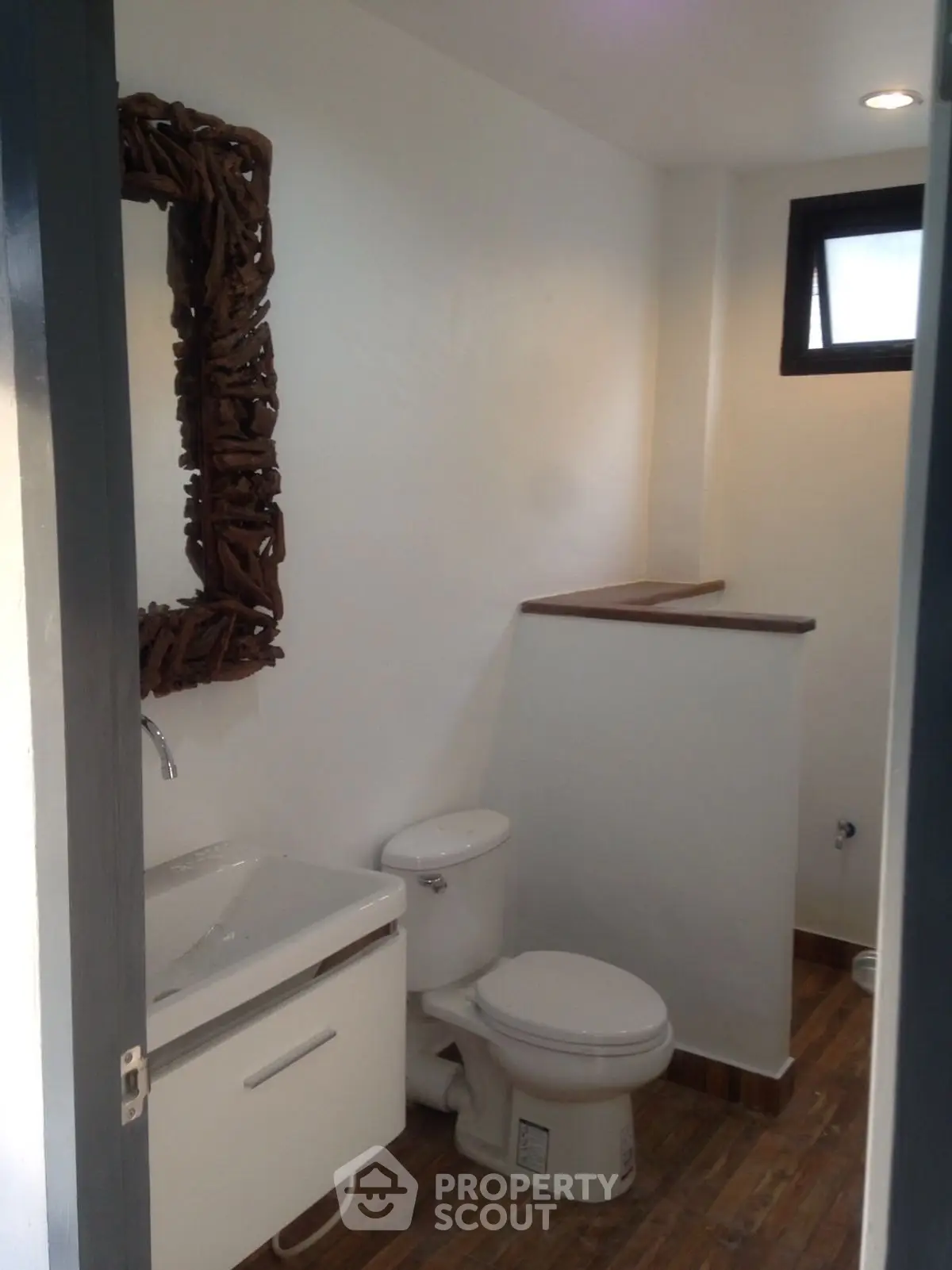 Modern bathroom with unique mirror and wooden accents
