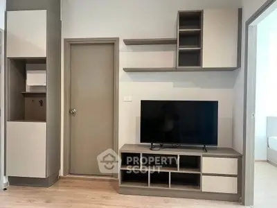 Modern living room with sleek TV unit and storage shelves in a stylish apartment.