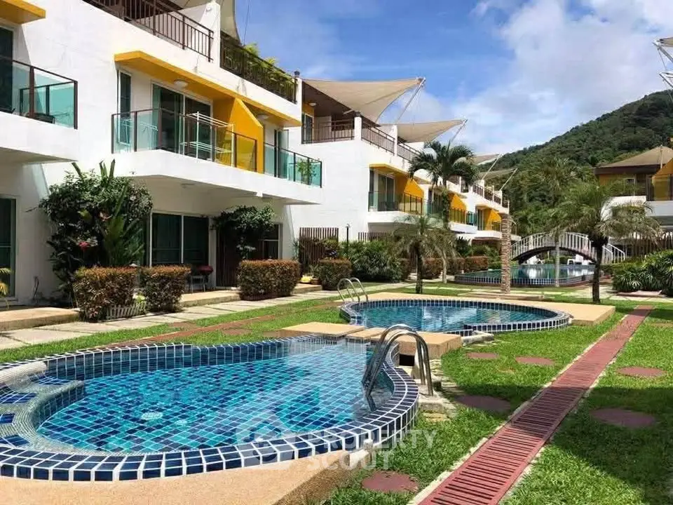 Luxurious apartment complex with stunning pool and lush greenery, perfect for resort-style living.