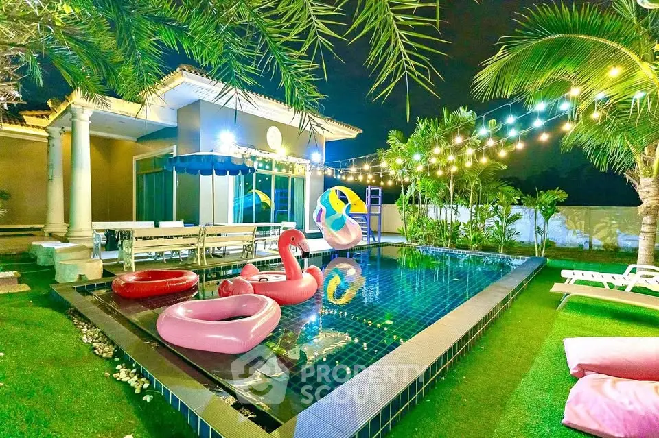 Luxurious villa with illuminated pool and tropical garden at night